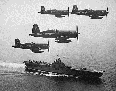 A flight of Corsair fighters passing over an aircraft carrier